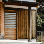 Close-up view of a traditional Japanese wooden house entrance with sliding door and vertical timber siding.