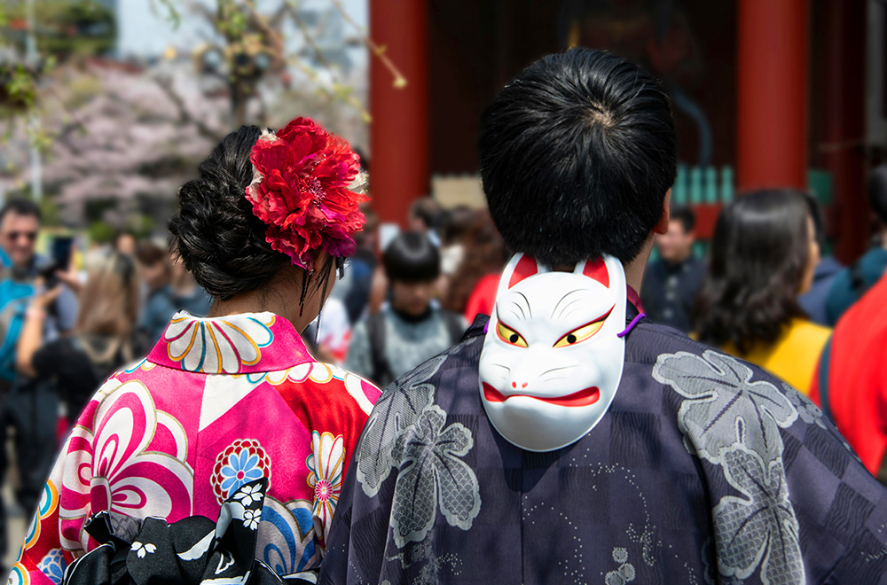 A Japanese man and Japanese woman dressed in traditional Japanese kimonos, showcasing vibrant colors and intricate patterns against a serene backdrop