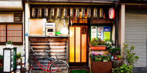 Traditional Japanese storefront with red bicycle and flower pots.