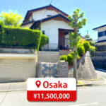 Two-story house with a modern roof and large windows, featuring a driveway and parking space, listed for sale in Japan.