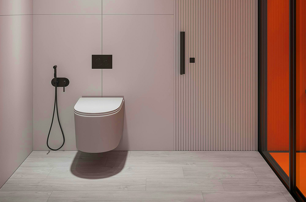Minimalist modern bathroom with a wall-mounted toilet, matte black bidet spray, pale pink wall panels, light wood flooring, and an orange-tinted glass door.